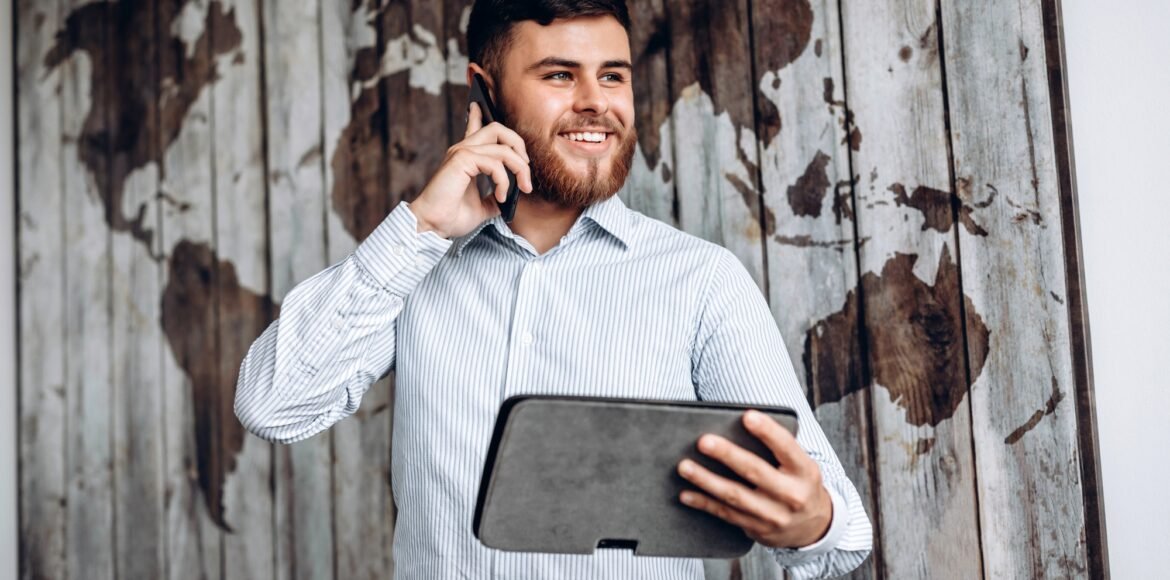Handsome busy businessman talking on the phone and looking at important document on tablet. Handsome busy businessman talking on the phone and looking at important document on tablet.